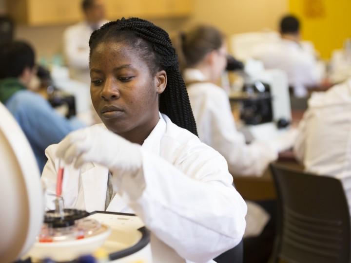 A student loading sample in the benchtop centrifuge